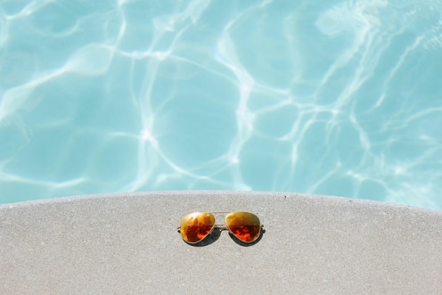 los imprescindibles para cuidar tu piscina. Gafas de sol en una piscina.